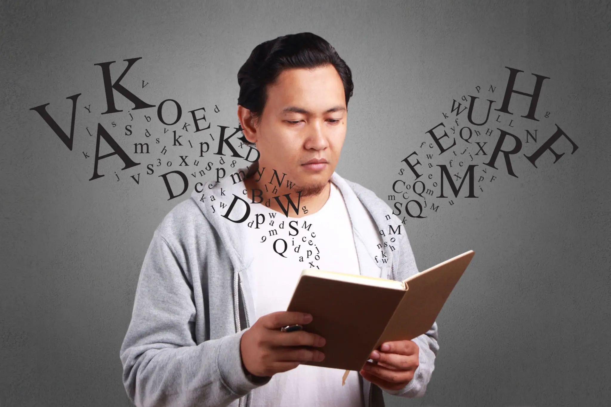 Man reading book with floating letters