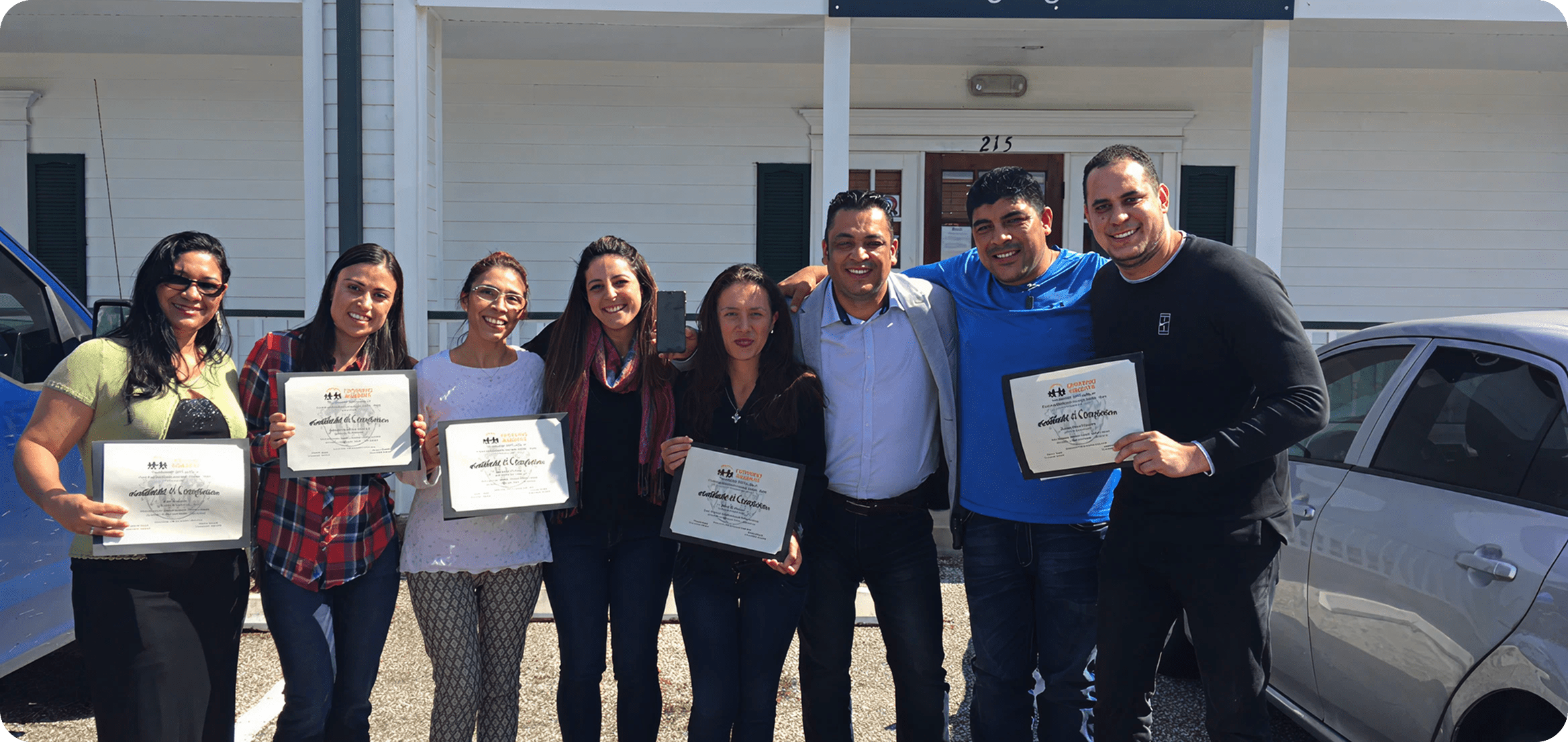 People smiling with certificates in hand