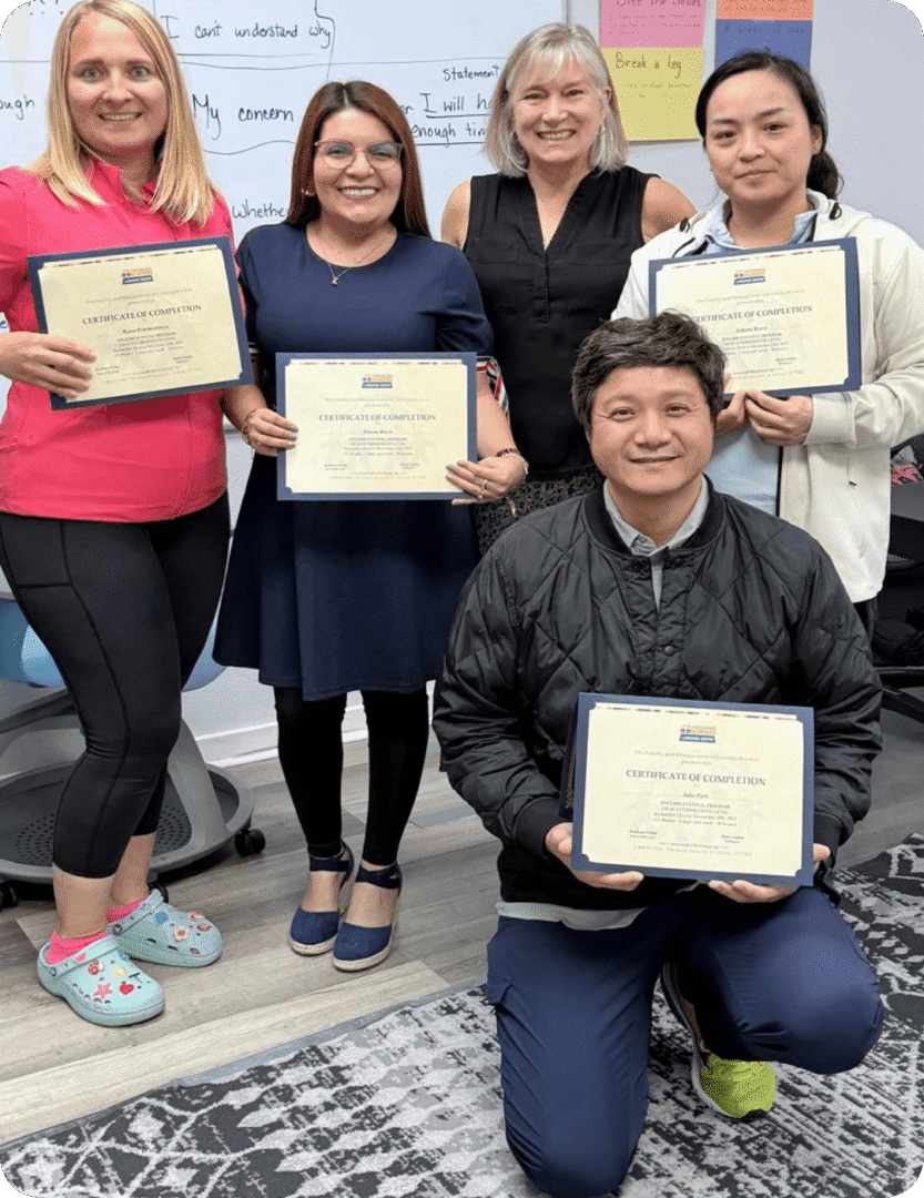 Group of five holding certificates in classroom