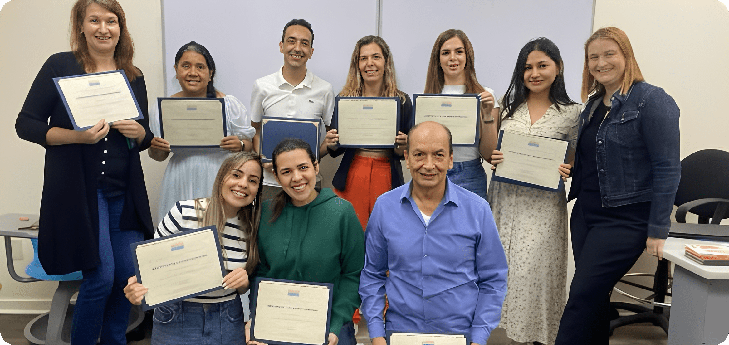 Smiling group holding certificates in classroom